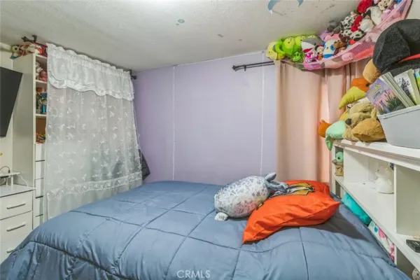 a bedroom with a bed and a potted plant