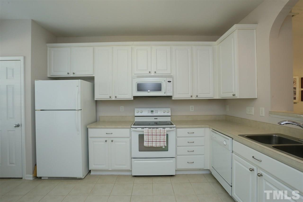 8228 City Loft Court Raleigh, NC 27613 - Photo 12 of 27 a kitchen with white cabinets and white appliances