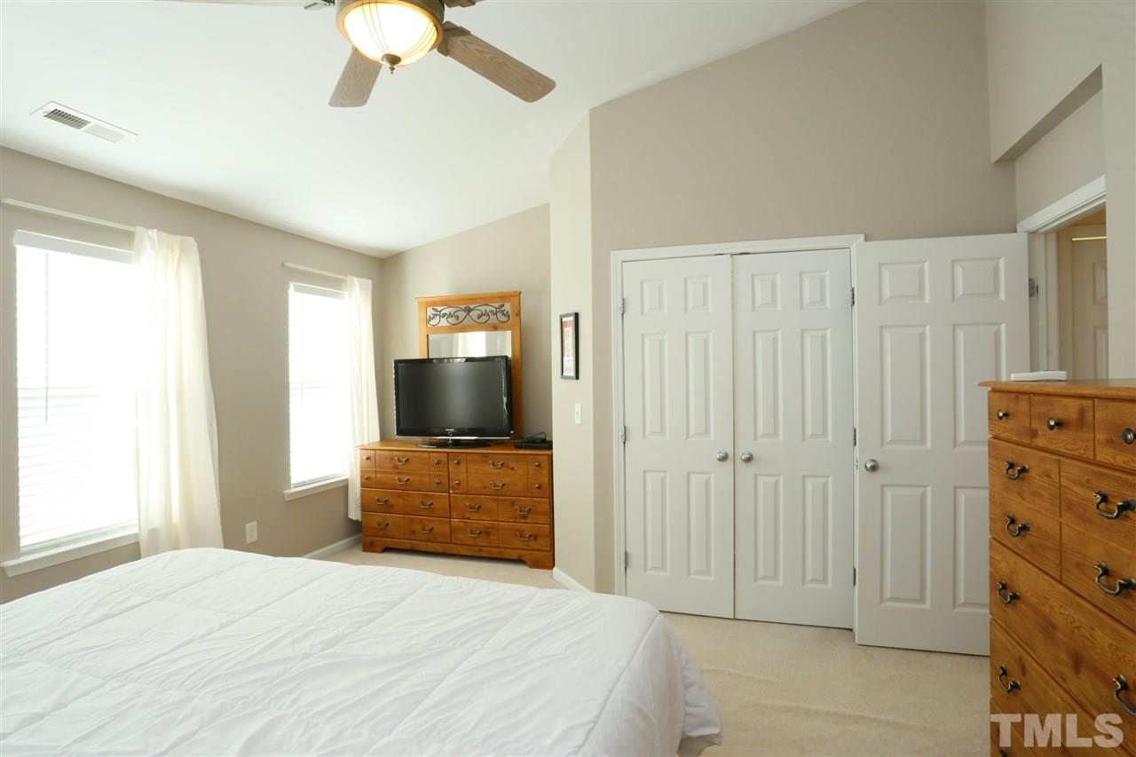 8228 City Loft Court Raleigh, NC 27613 - Photo 18 of 27 a bedroom with a bed and a chandelier