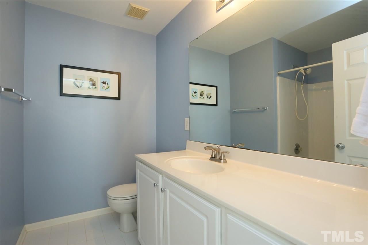 8228 City Loft Court Raleigh, NC 27613 - Photo 19 of 27 a bathroom with a sink mirror and toilet