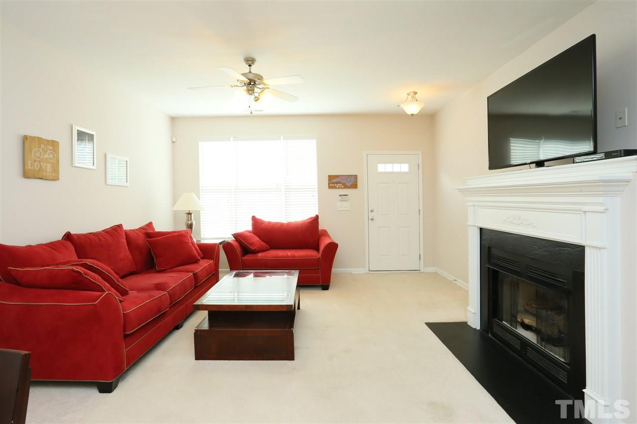 8228 City Loft Court Raleigh, NC 27613 - Photo 5 of 27 a living room with furniture a flat screen tv and a fireplace