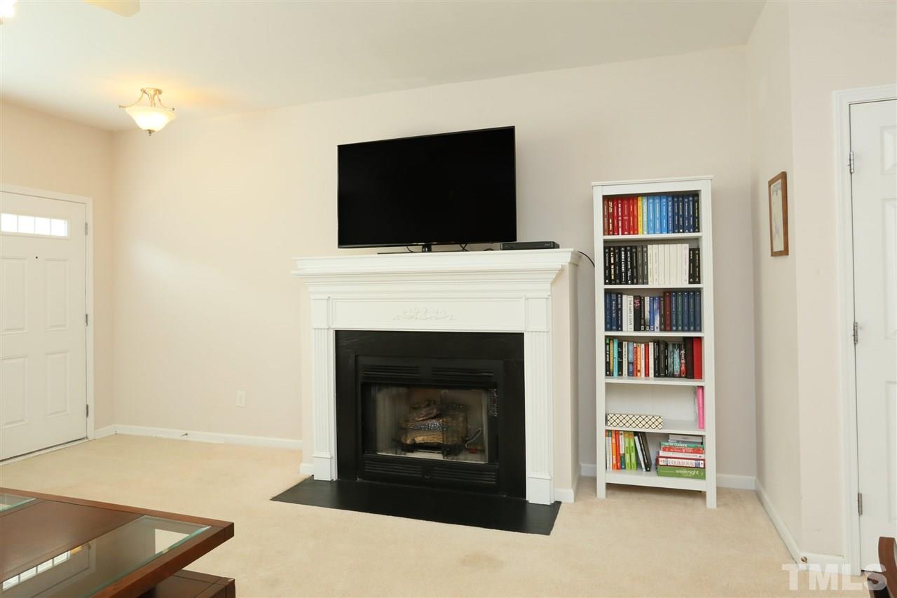 8228 City Loft Court Raleigh, NC 27613 - Photo 6 of 27 a living room with a fireplace and a flat screen tv