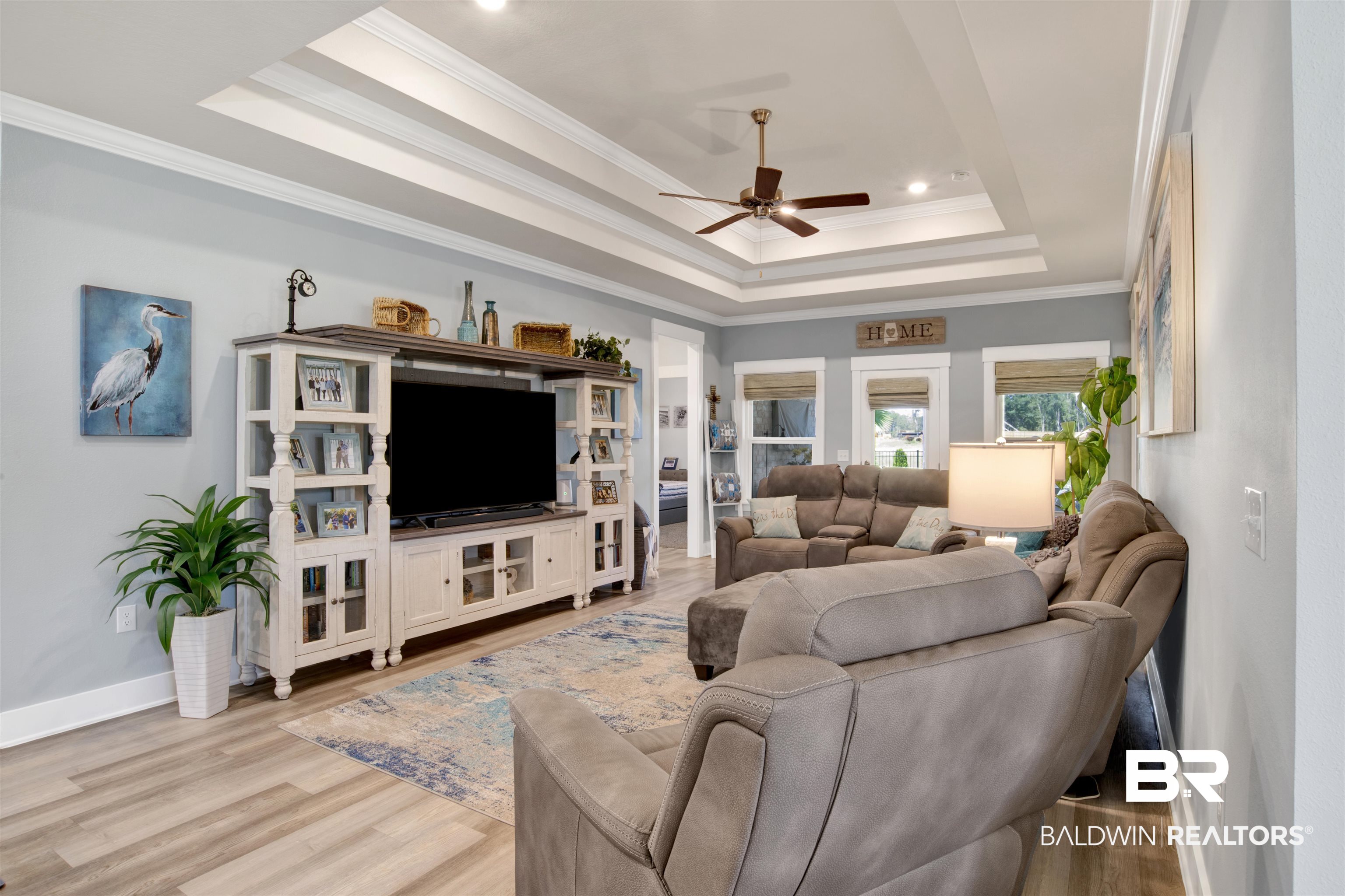 10113 Lakeview Drive Foley, AL 36535 - Photo 16 of 34 Living room featuring light wood-type flooring, a tray ceiling, ornamental molding, and ceiling fan