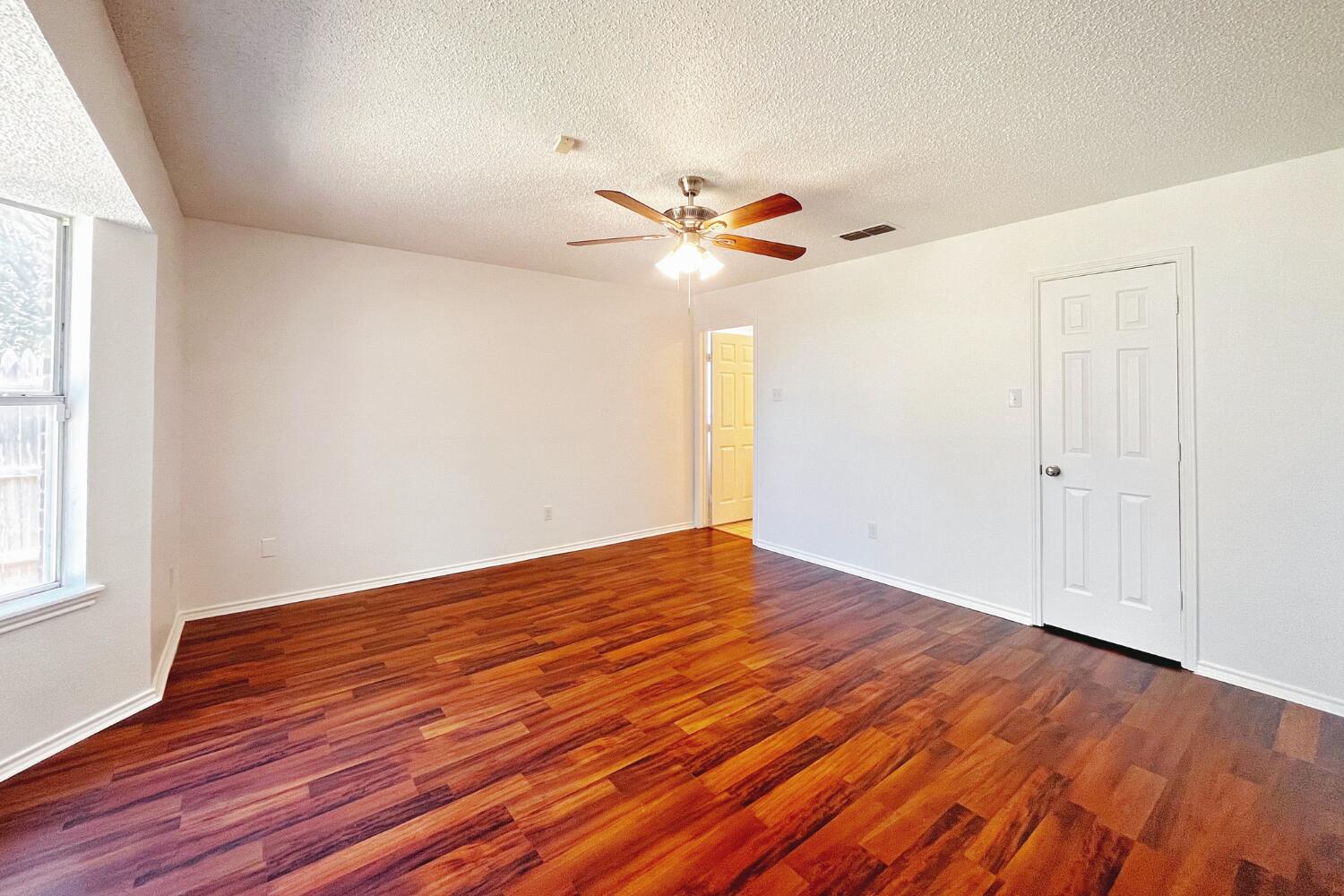 6114 10th Street Lubbock, TX 79416 - Photo 11 of 24 wooden floor in an empty room with a window