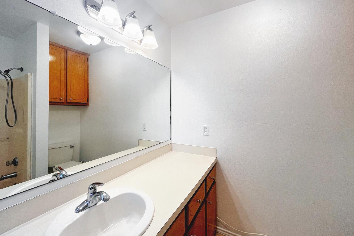 6114 10th Street Lubbock, TX 79416 - Photo 13 of 24 a bathroom with a sink and a mirror