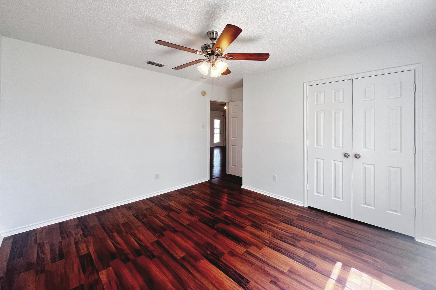 6114 10th Street Lubbock, TX 79416 - Photo 16 of 24 a view of an empty room with wooden floor