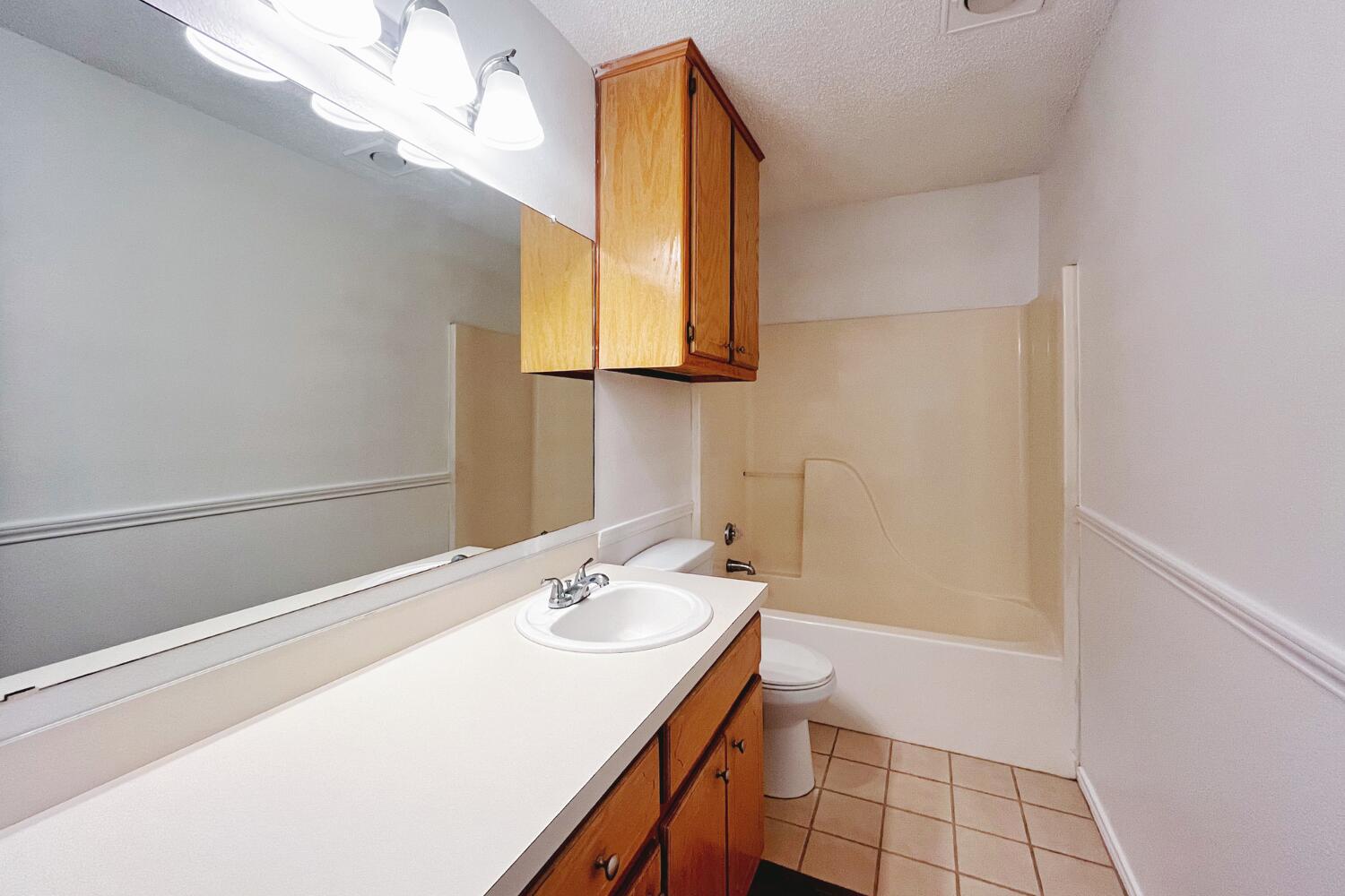 6114 10th Street Lubbock, TX 79416 - Photo 17 of 24 a bathroom with a sink and a mirror