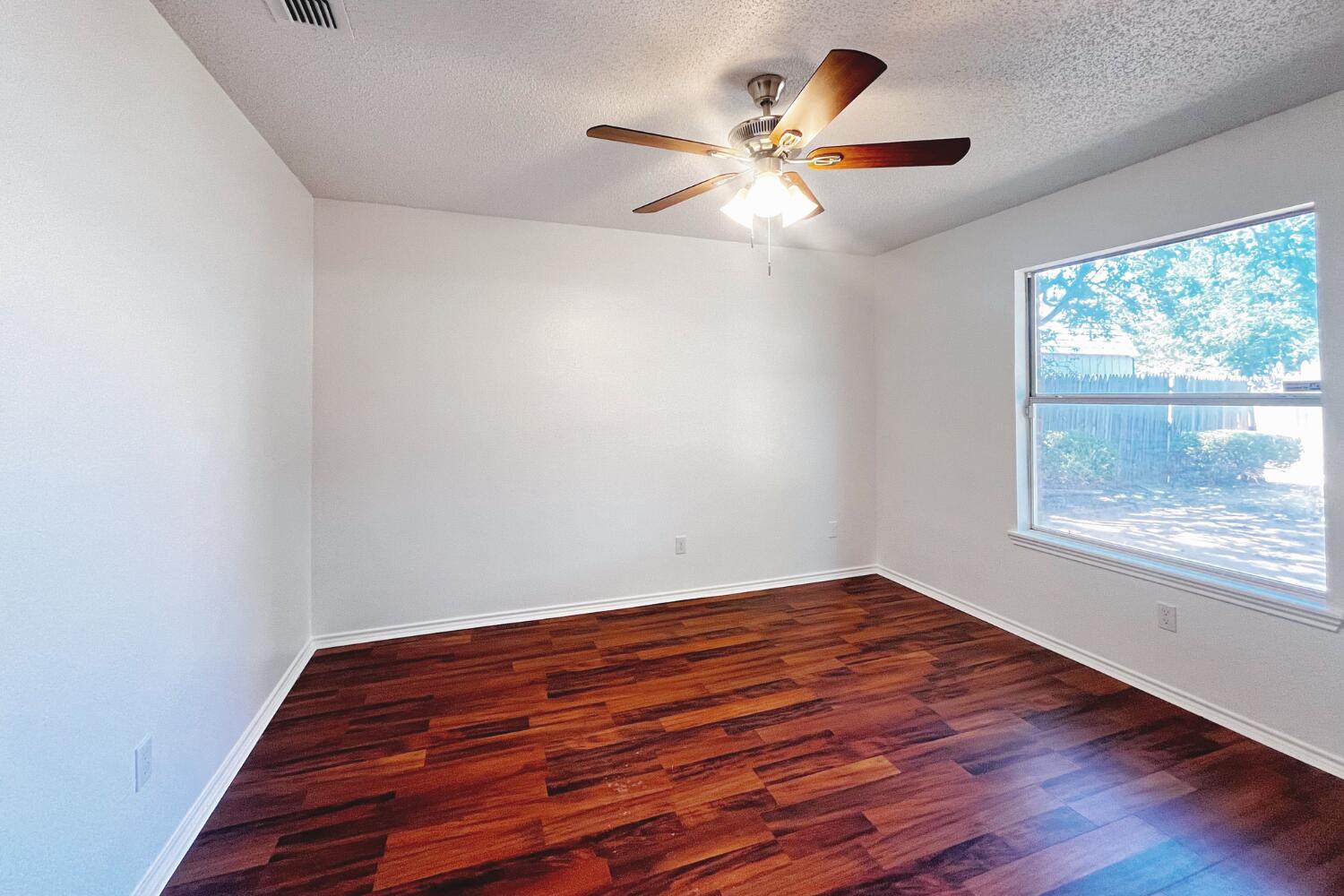 6114 10th Street Lubbock, TX 79416 - Photo 19 of 24 wooden floor in an empty room with a window