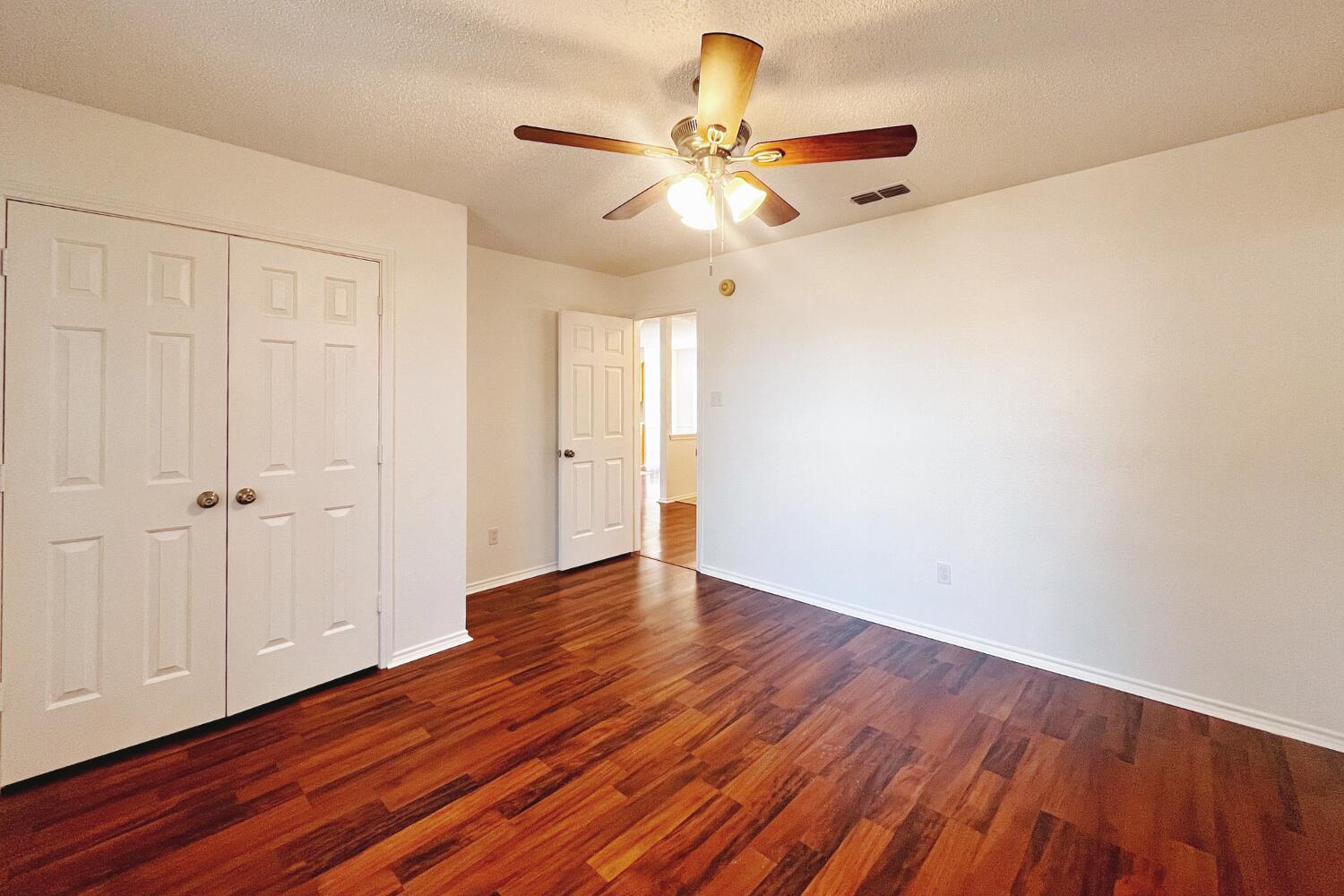 6114 10th Street Lubbock, TX 79416 - Photo 20 of 24 a view of an empty room with wooden floor