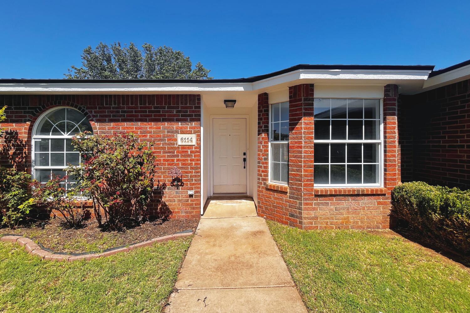 6114 10th Street Lubbock, TX 79416 - Photo 2 of 24 a front view of a house with garden