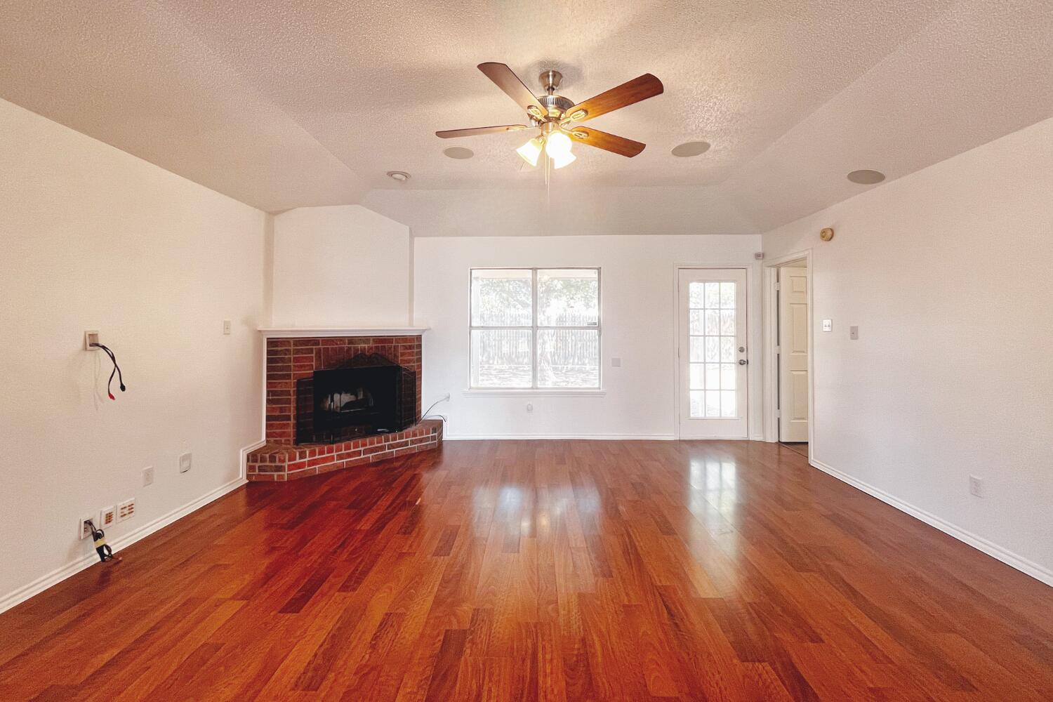 6114 10th Street Lubbock, TX 79416 - Photo 4 of 24 wooden floor in an empty room with a fireplace