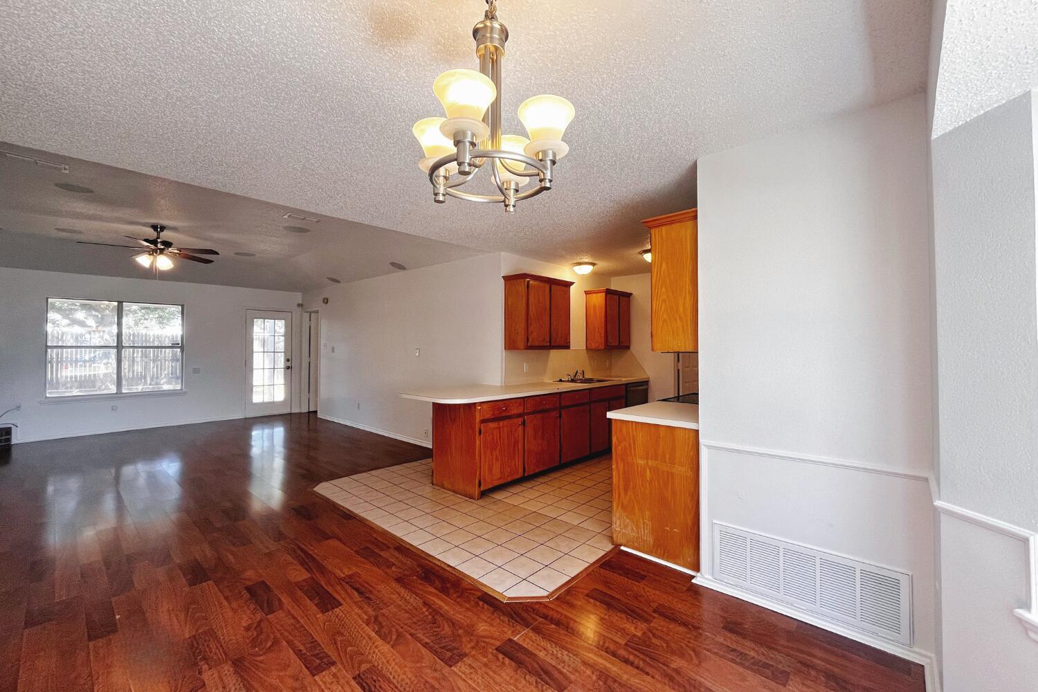6114 10th Street Lubbock, TX 79416 - Photo 6 of 24 wooden floor with chandelier and wooden floor