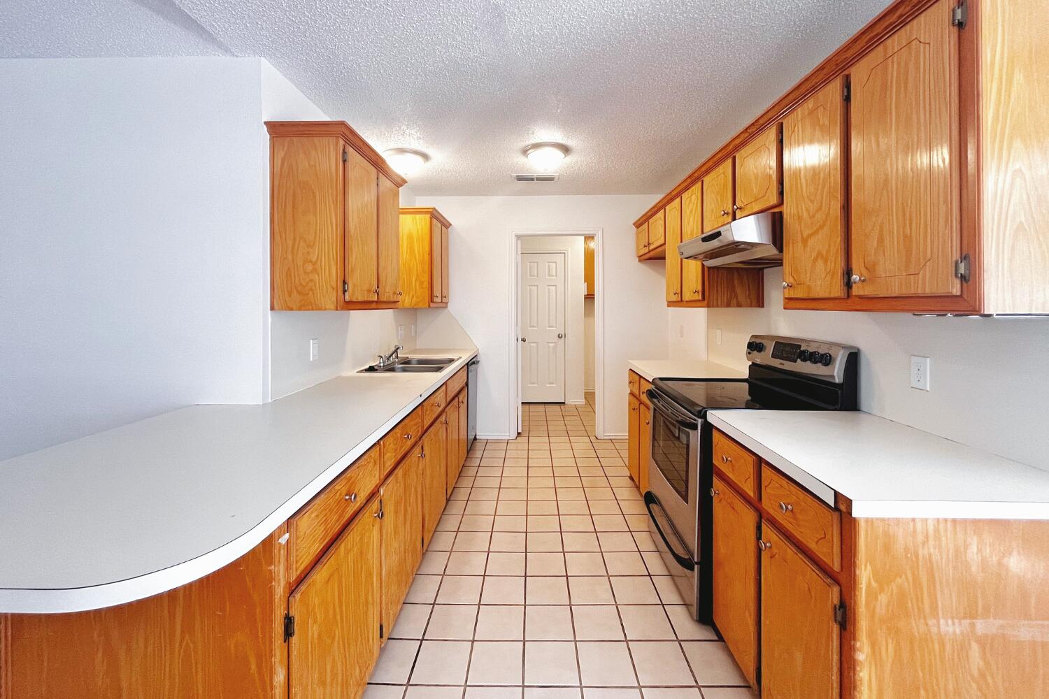 6114 10th Street Lubbock, TX 79416 - Photo 7 of 24 a kitchen with a sink a counter top space and cabinets