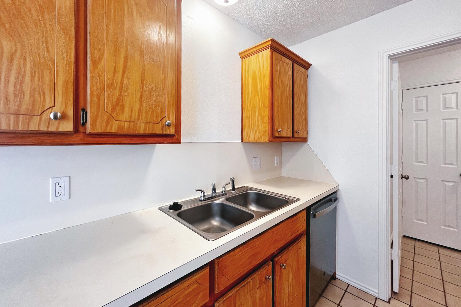 6114 10th Street Lubbock, TX 79416 - Photo 8 of 24 a kitchen with stainless steel appliances granite countertop a sink a stove and a microwave oven with cabinets
