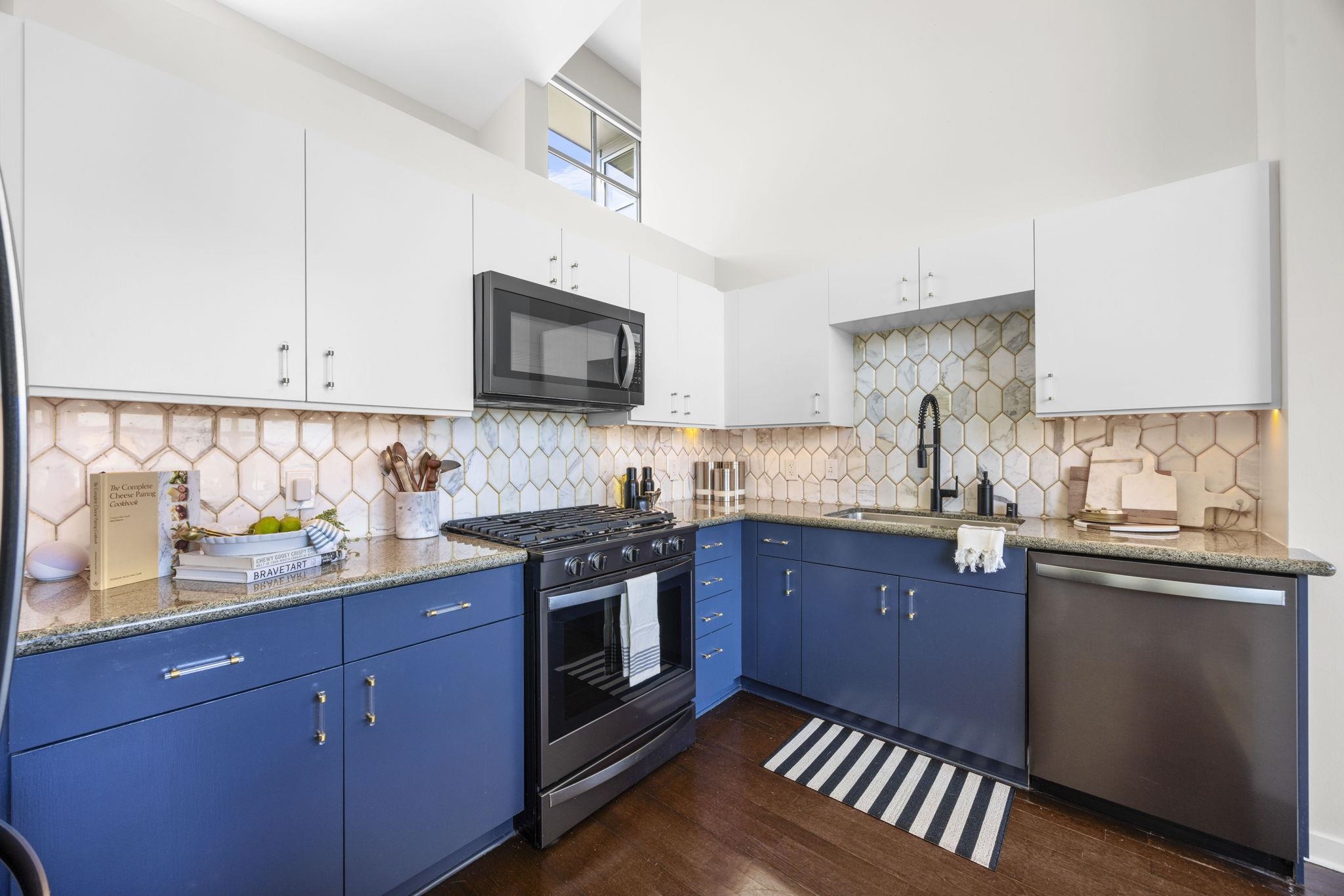 1007 41st Street, Unit 334 Oakland, CA 94608 - Photo 15 of 59 a kitchen with stainless steel appliances granite countertop a stove a sink dishwasher and a microwave oven with wooden cabinets
