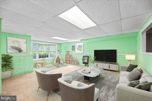 a living room with furniture a window and a flat screen tv