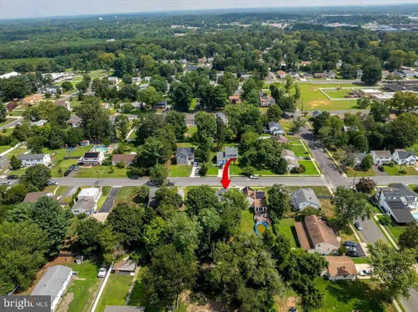 an aerial view of residential houses with outdoor space and trees