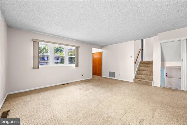 an empty room with a window and stairs
