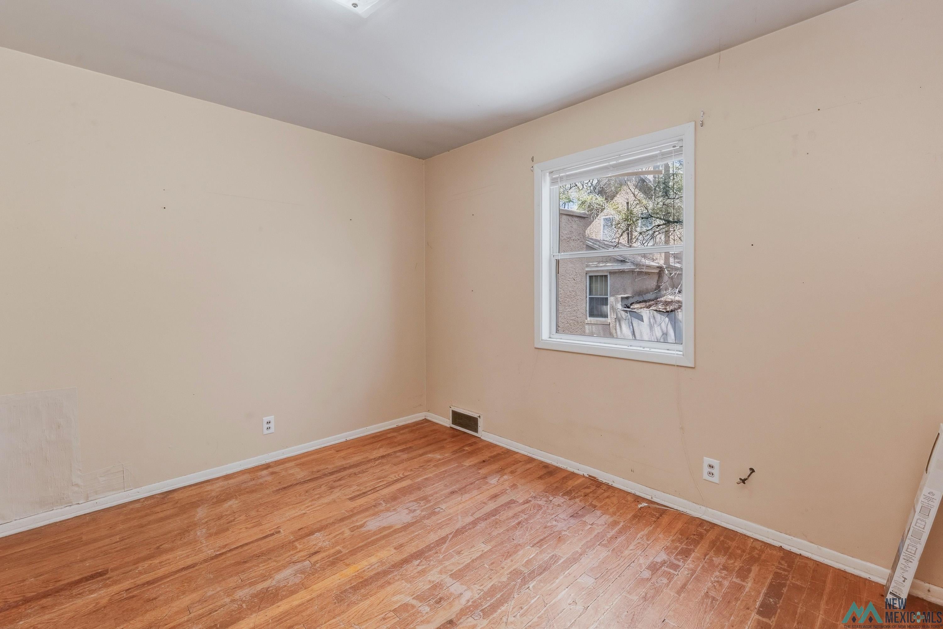 533 South 2nd Street Raton, NM 87740 - Photo 28 of 43 Room with hardwood flooring, a window, and light-colored walls