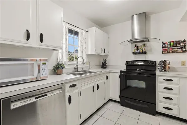 a kitchen with granite countertop white cabinets and white appliances