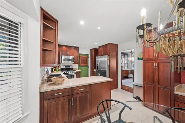 a kitchen with stainless steel appliances a sink cabinets and wooden floor