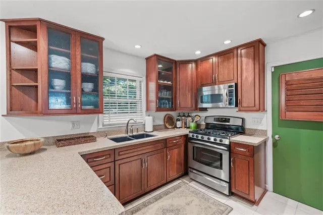 a kitchen with stainless steel appliances granite countertop a stove sink and cabinets