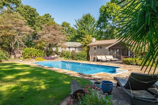 a view of house with swimming pool and sitting area