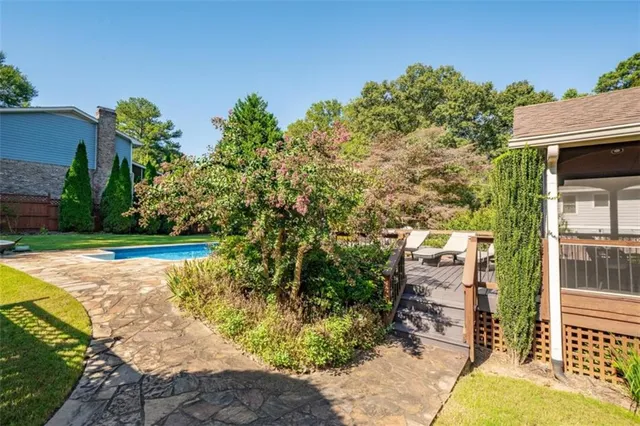 a view of a house with a yard and a large tree