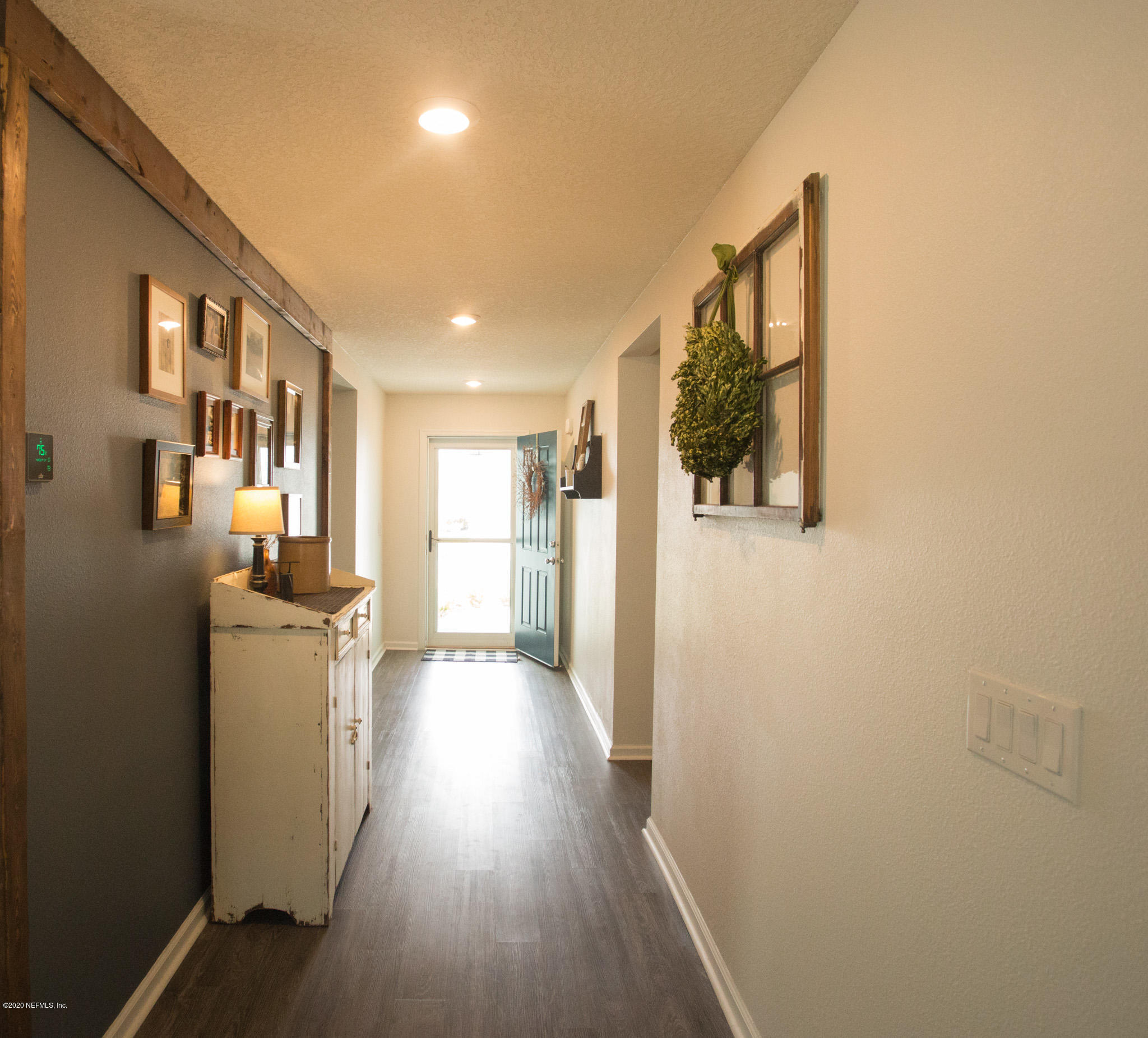 92 Bluejack Lane St. Augustine, FL 32095 - Photo 14 of 44 a view of a hallway with wooden floor and a kitchen