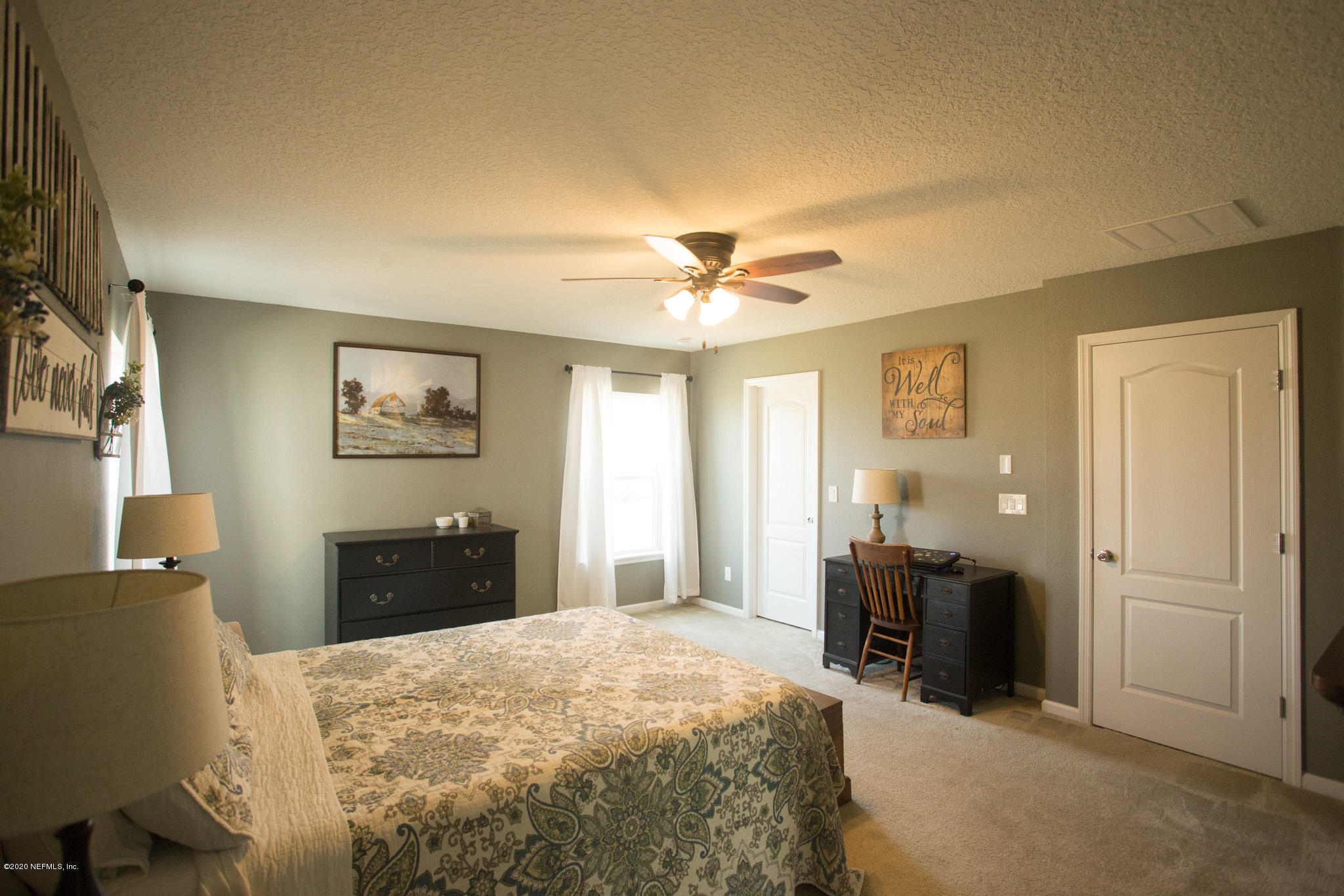92 Bluejack Lane St. Augustine, FL 32095 - Photo 28 of 44 a spacious bedroom with a bed and a chandelier