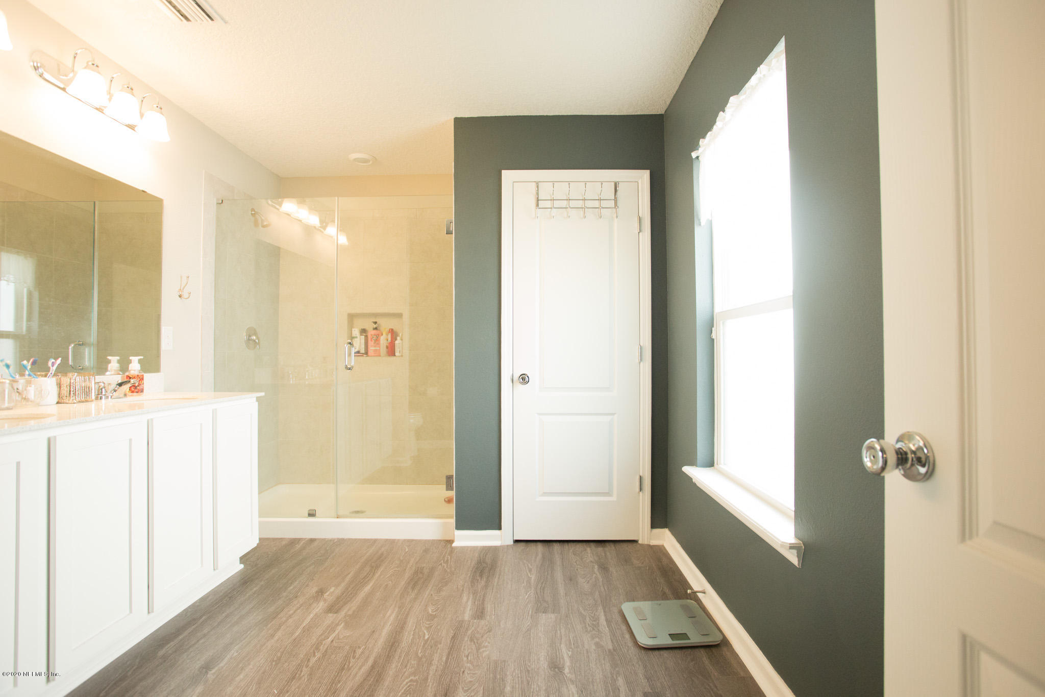 92 Bluejack Lane St. Augustine, FL 32095 - Photo 30 of 44 a bathroom with a sink a mirror a vanity and a shower