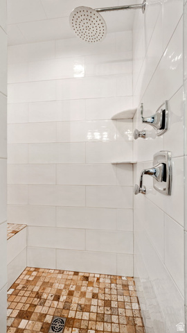 1238 Canyon View Road Midway, UT 84049 - Photo 22 of 36 Shower with white subway tile walls, a built-in bench, a rain showerhead, chrome fixtures, and natural stone mosaic floor tiling