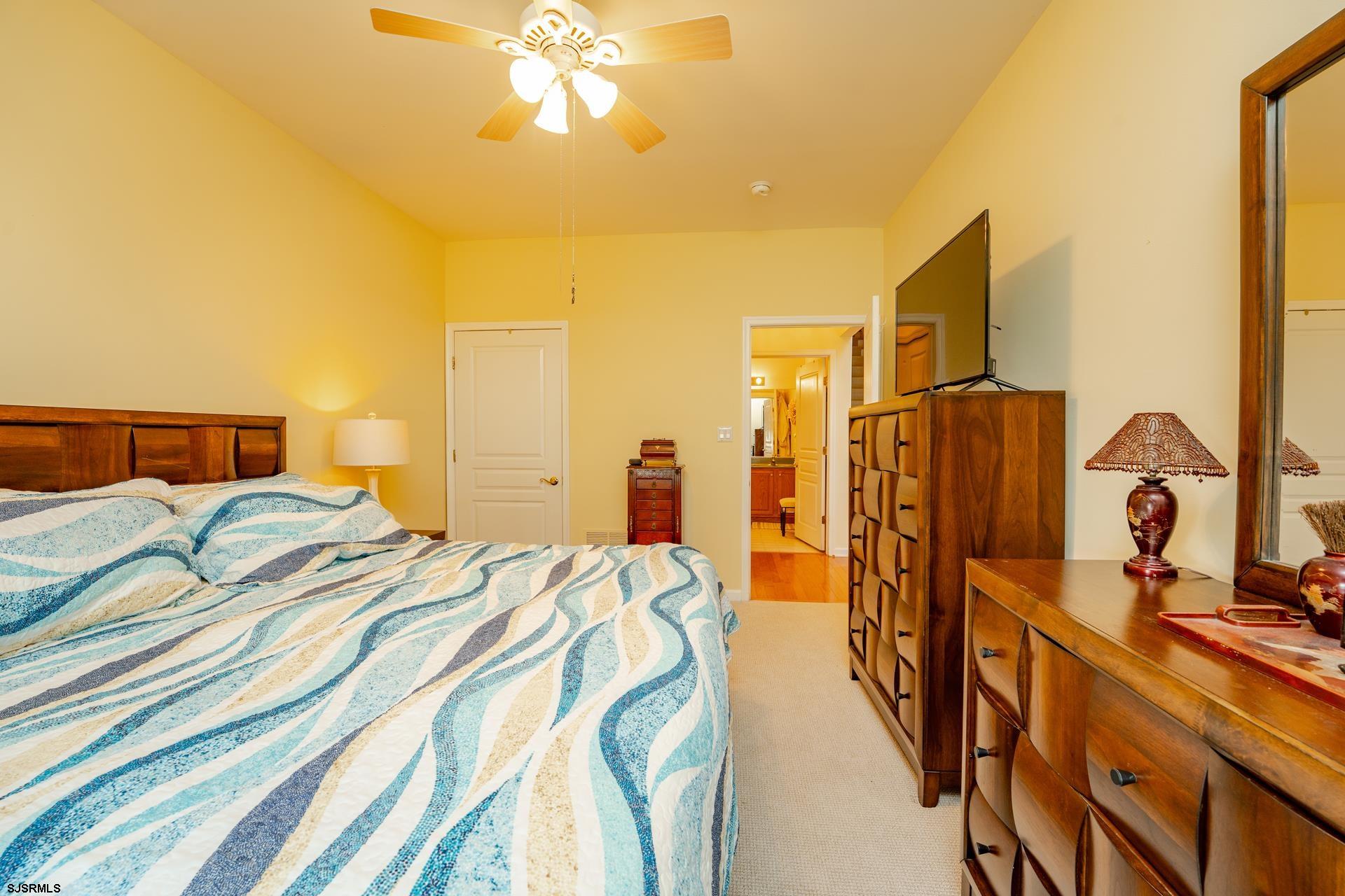 1731 Highway 9, Unit 28 Ocean View, NJ 08230 - Photo 25 of 41 a bedroom with a bed and a chandelier