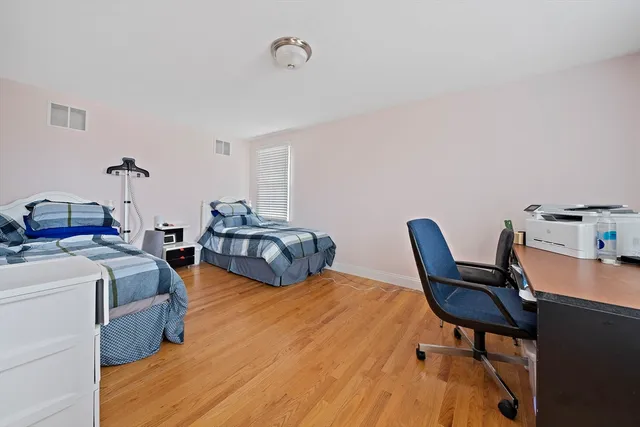 a bedroom with two beds and a desk