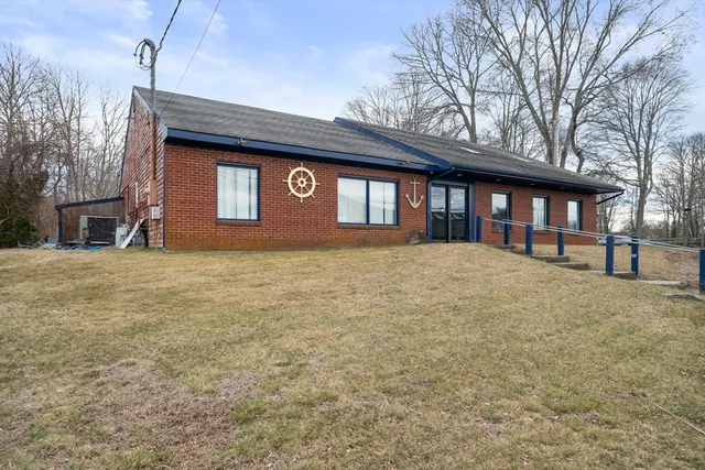 a front view of a house with large trees