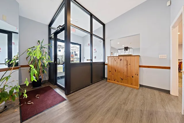 a view of a hallway with wooden floor and a potted plant