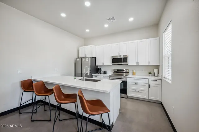 a kitchen with white cabinets and stainless steel appliances