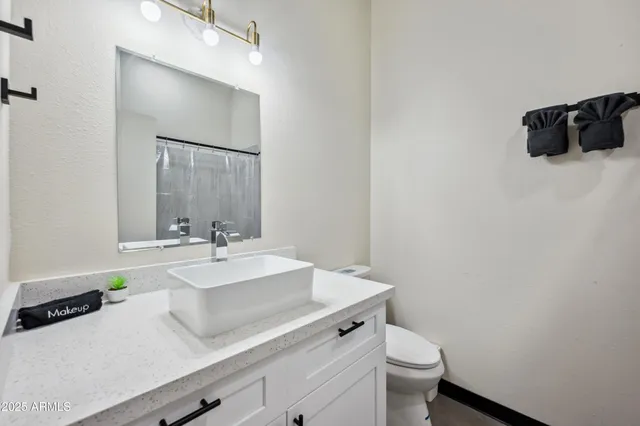 a bathroom with a sink a toilet and mirror