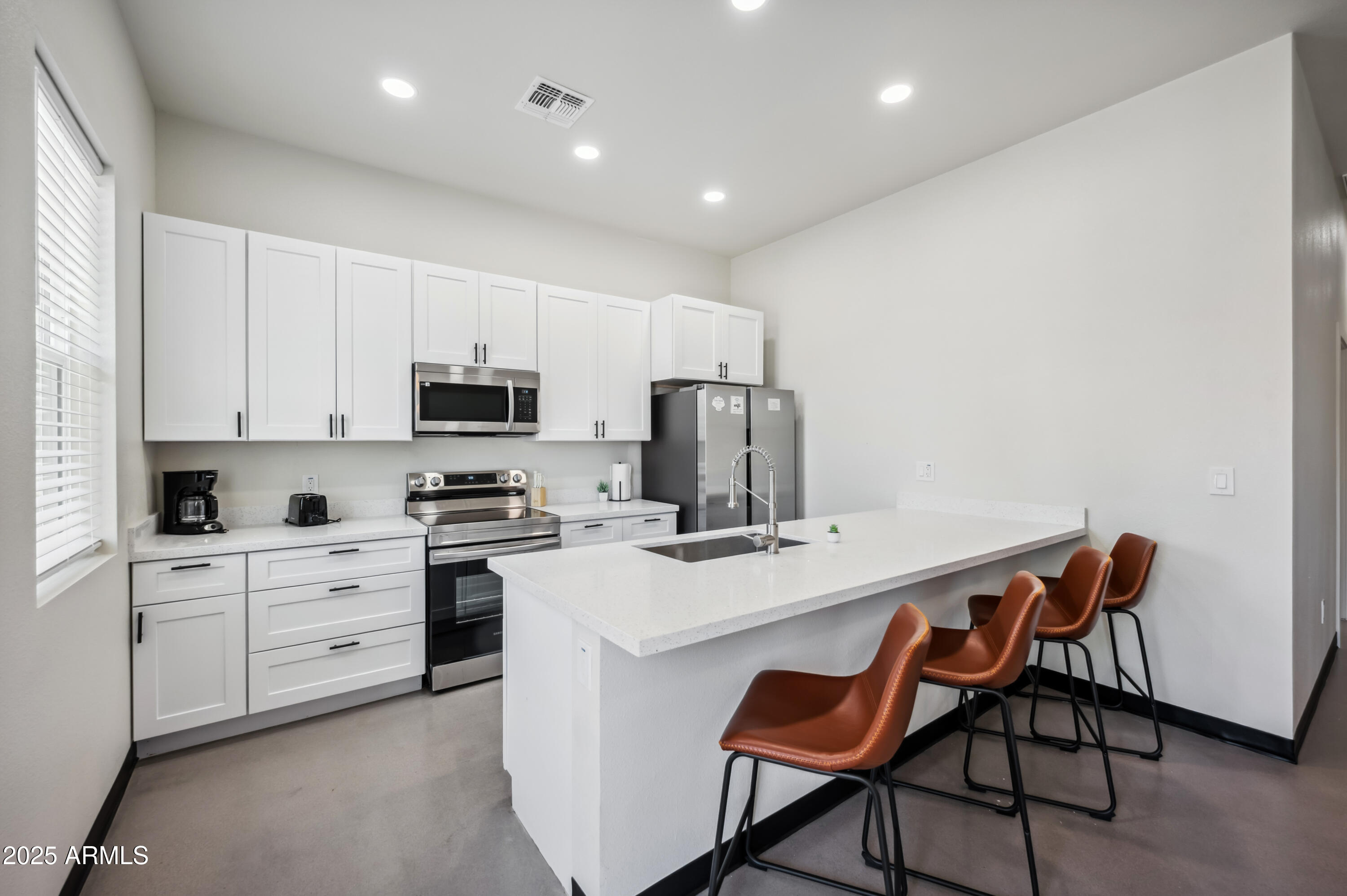 4136 North 11th Street Phoenix, AZ 85014 - Photo 9 of 33 a kitchen with a stove a sink a dining table and chairs
