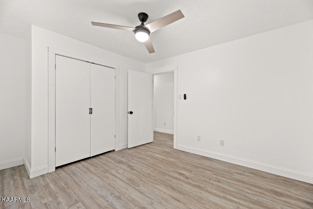 403 Wells Spring Road Dandridge, TN 37725 - Photo 13 of 24 an empty room with wooden floor ceiling fan and window