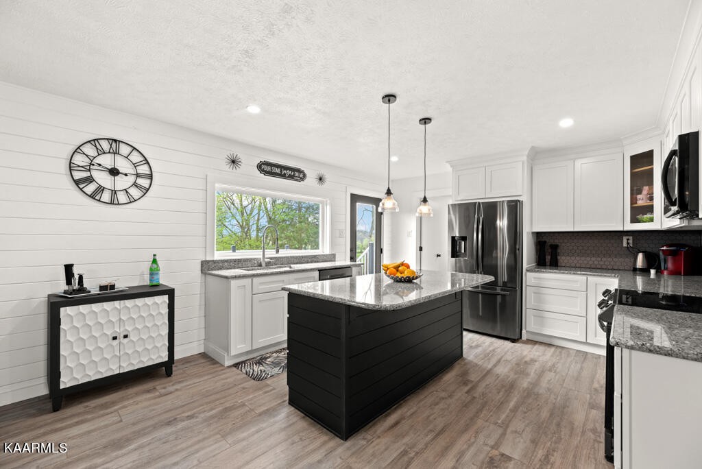 403 Wells Spring Road Dandridge, TN 37725 - Photo 8 of 24 a kitchen with stainless steel appliances kitchen island granite countertop a sink a stove and a refrigerator