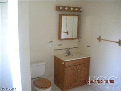 2308 Lotus Road Fort Myers, FL 33905 - Photo 3 of 8 a bathroom with a toilet a sink and mirror