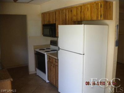 2308 Lotus Road Fort Myers, FL 33905 - Photo 5 of 8 a white refrigerator freezer and a stove sitting inside of a kitchen