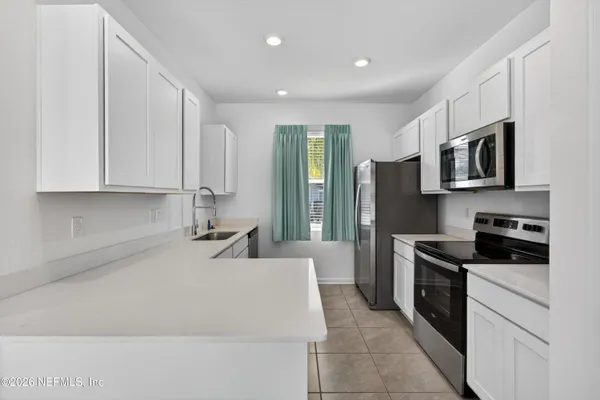 a kitchen with stainless steel appliances granite countertop a refrigerator sink and stove