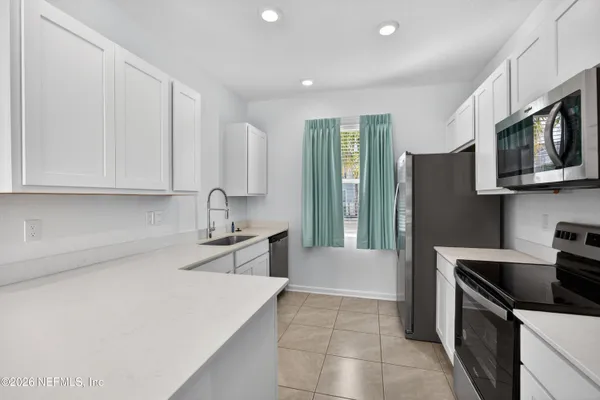 a kitchen with stainless steel appliances a stove microwave and sink