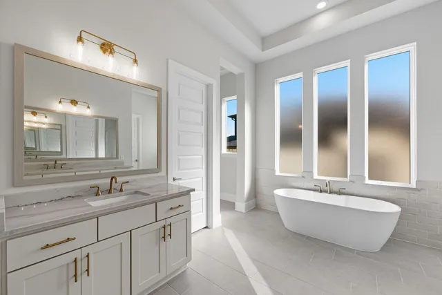 a spacious bathroom with a double vanity sink mirror and bathtub