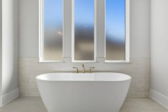 a bathroom with a bathtub and mirror