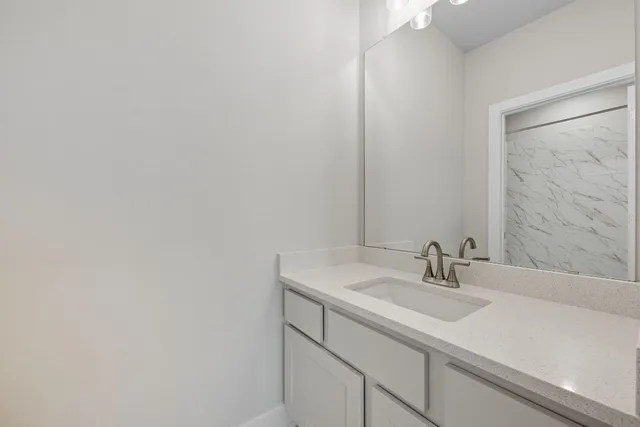 a bathroom with a granite countertop toilet sink and mirror