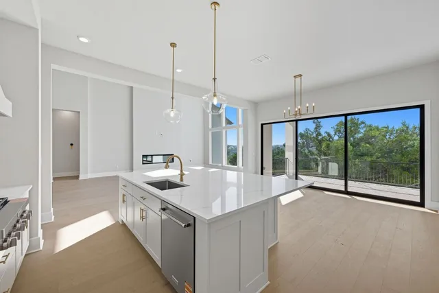 a kitchen with stainless steel appliances granite countertop a sink and a large window
