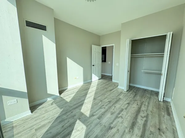 a view of empty room with wooden floor